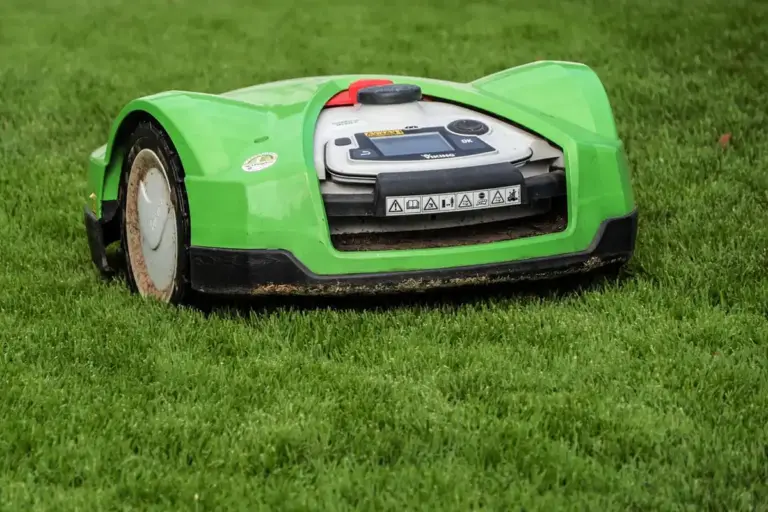 Green robotic lawn mower on a lush green lawn