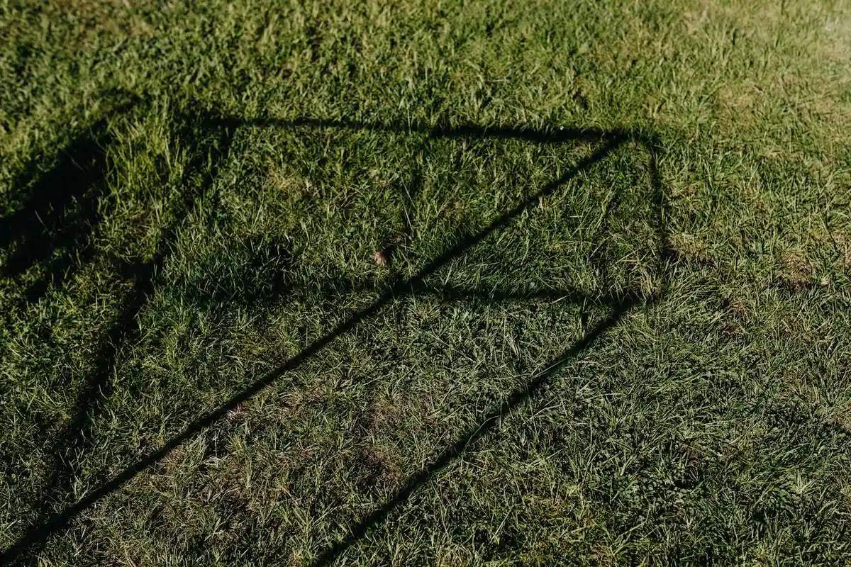 Shadow of a lawn aerator cast on a grassy lawn