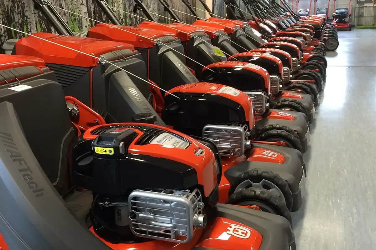 Row of red and black lawn tractors lined up in a showroom.