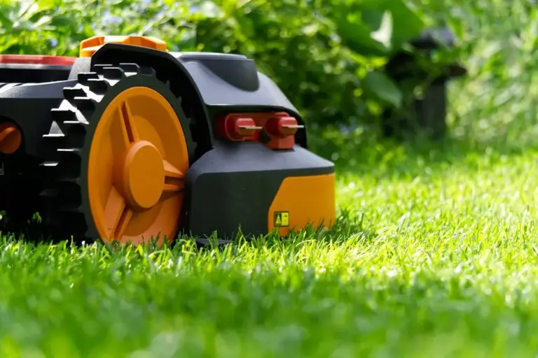 Close-up of a modern lawn mower on bright green grass, ready for mowing