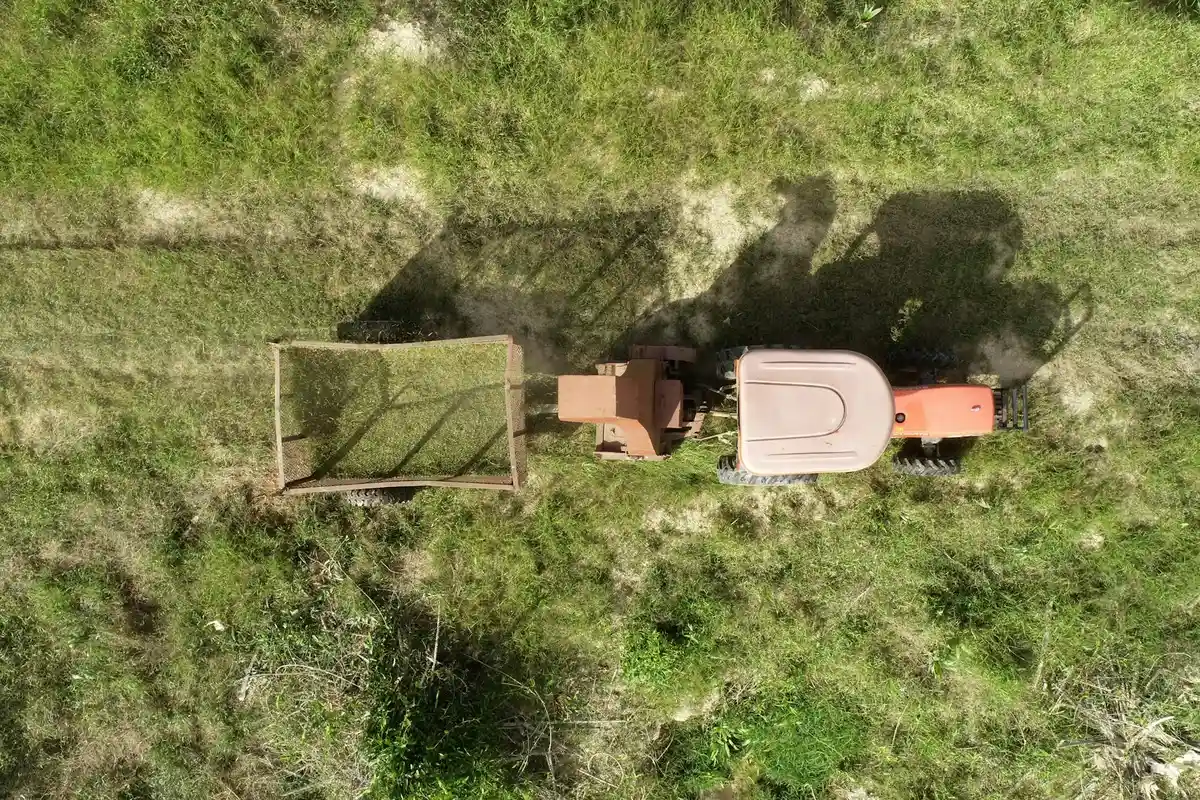 Top-down view of a riding lawn mower with a deck attachment on a grassy area.