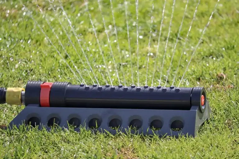 Lawn sprinkler watering green grass