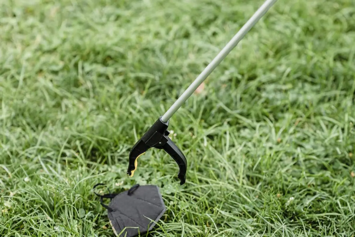 Close-up of a lawn care tool resting on dense, green zoysia grass.